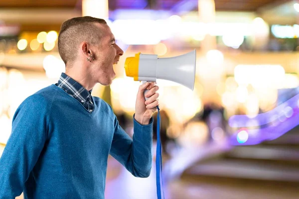 Redhead man shouting by megaphone over white background — Stock Photo, Image