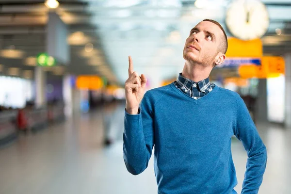 Young man pointing up over white background