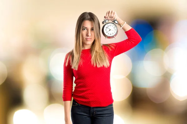 Молодая девушка держит антикварные часы на белом фоне — стоковое фото