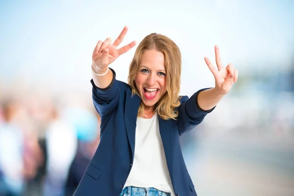 Žena, která dělá gesto vítězství nad bílým pozadím — Stock fotografie