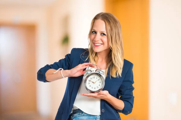 Κοπέλα που κρατά ένα ρολόι πάνω από το λευκό φόντο — Φωτογραφία Αρχείου