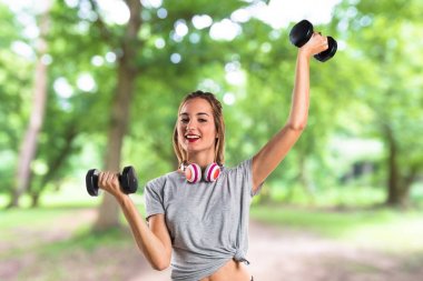 Genç kadının halter parkta yapması