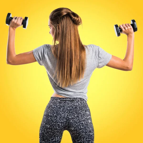 Mujer joven haciendo levantamiento de pesas —  Fotos de Stock