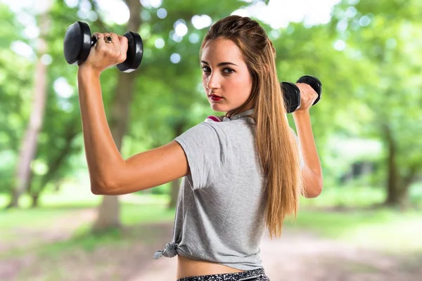 Giovane donna che fa sollevamento pesi al parco — Foto Stock