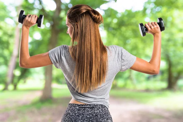 Giovane donna che fa sollevamento pesi al parco — Foto Stock