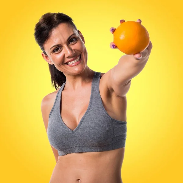 Sport woman with an orange Royalty Free Stock Images