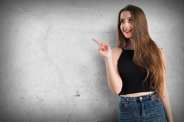 Chica joven apuntando hacia arriba — Foto de Stock