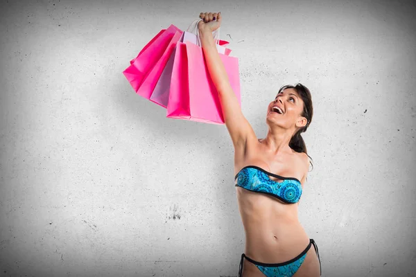 Mujer en bikini con muchas bolsas de compras —  Fotos de Stock