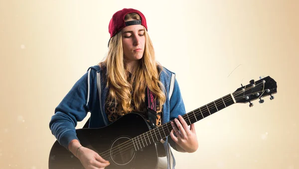 Meisje gitaarspelen op okergeel achtergrond — Stockfoto