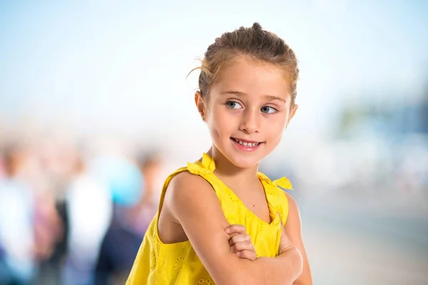 Blond liten flicka gå med armarna korsade — Stockfoto