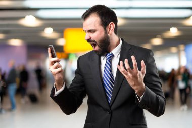 İzole arka plan üzerinde cep bağırarak genç işadamları. 