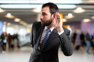 bir şey beyaz arka plan üzerinde işitme genç iş adamı 