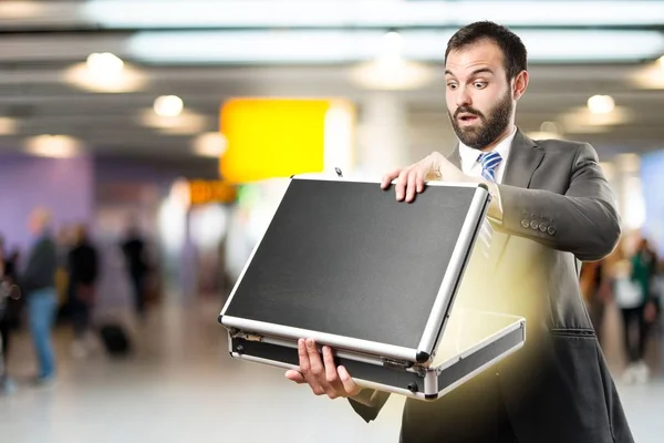 Young businessman open his briefcase over white background — Stock Photo, Image