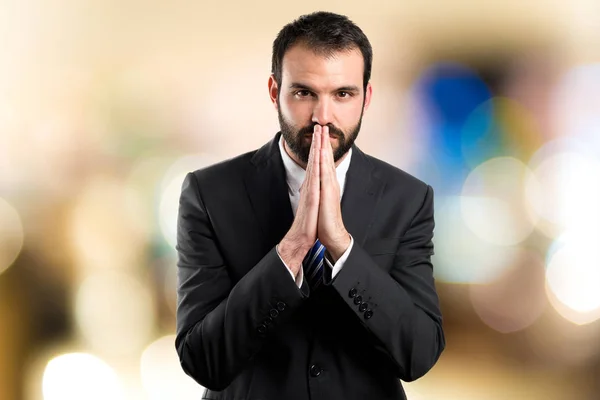 Young businessman pleading over white background — Stock Photo, Image