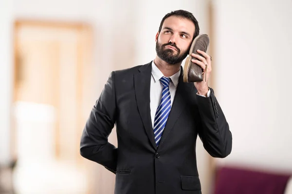 Joven hombre de negocios hablando con su zapato sobre fondo blanco —  Fotos de Stock