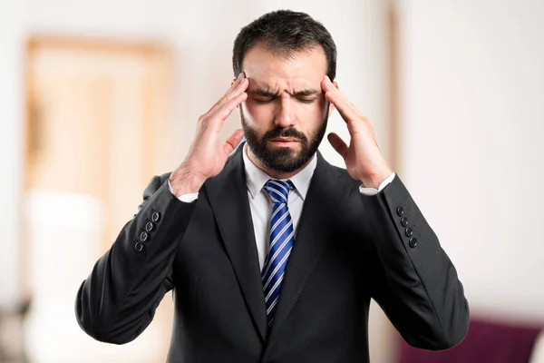 Junger Geschäftsmann mit Kopfschmerzen über weißen Hintergrund — Stockfoto