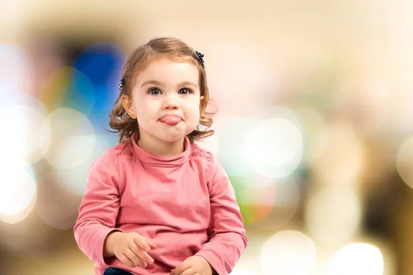 Söt baby flicka sticker ut tungan över vit bakgrund — Stockfoto