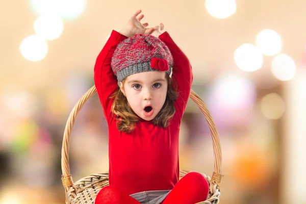Surprised cute baby inside basket  on unfocused background — Stock Photo, Image
