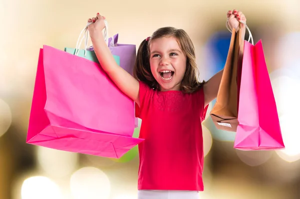 Menina com muitos sacos de compras em fundo desfocado — Fotografia de Stock