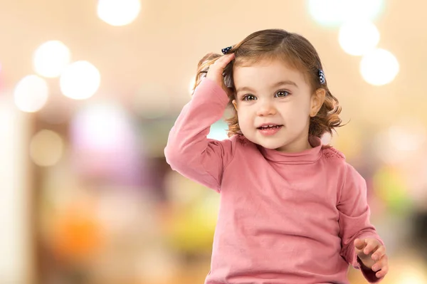 Liten flicka sitter över vit bakgrund — Stockfoto