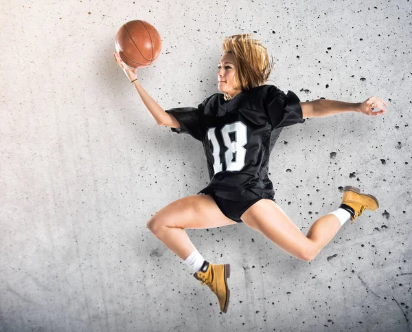 Mujer saltando y jugando baloncesto — Foto de Stock