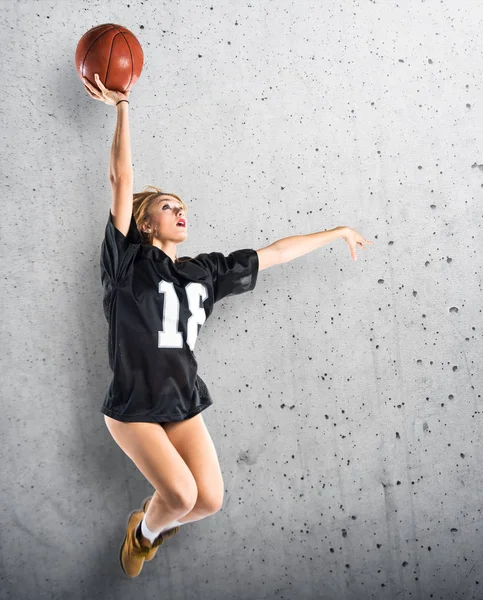 Woman jumping and playing basketball — Stock Photo, Image