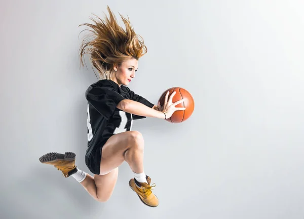 Žena skákat a hrát basketbal — Stock fotografie