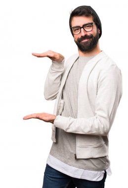 Bir şey beyaz arka plan üzerinde tutan hipster adam
