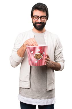 Mutlu Hipster adam yeme popcorns beyaz arka plan üzerinde