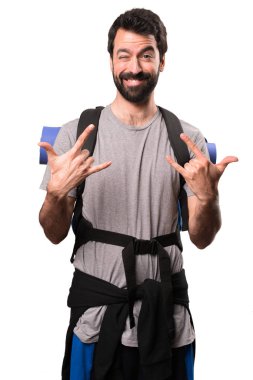 Yakışıklı backpacker yapma rock jest beyaz arka plan üzerinde