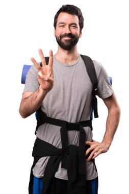 Yakışıklı backpacker üç beyaz arka plan üzerinde sayma