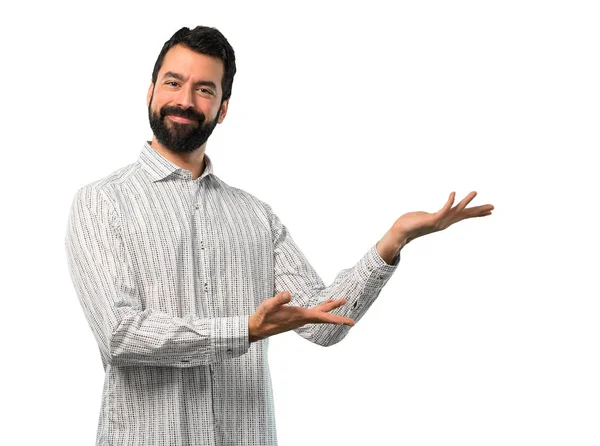 Bonito homem com barba apresentando e convidando para vir — Fotografia de Stock