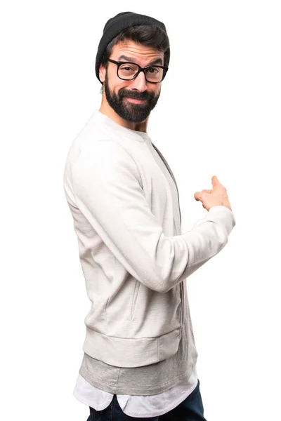 Hipster homem apontando para trás no fundo branco — Fotografia de Stock
