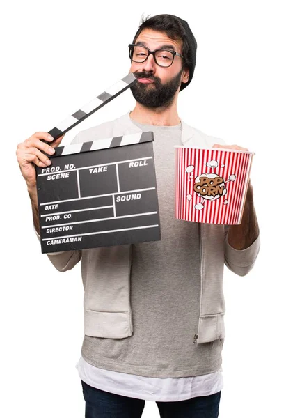 Hipster man holding a clapperboard on white background — Stock Photo, Image