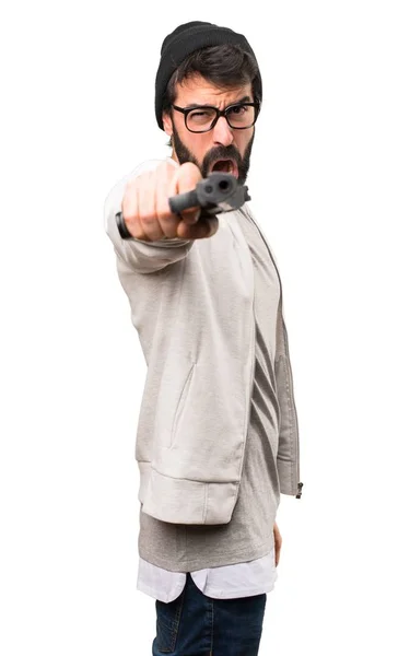 Hipster man schieten met een pistool op witte achtergrond — Stockfoto