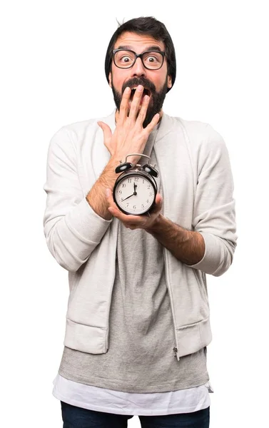 Surprised Hipster man holding vintage clock on white background — Stock Photo, Image