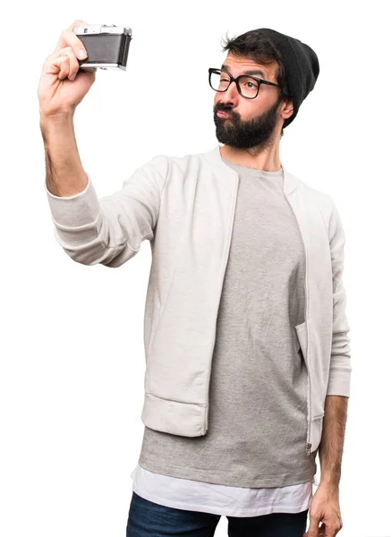 Hipster-mannen som innehar en kamera på vit bakgrund — Stockfoto