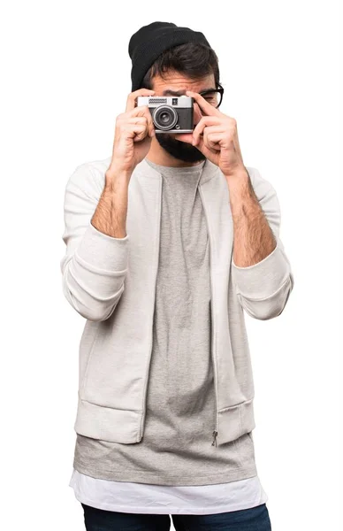 Hipster homem segurando uma câmera no fundo branco — Fotografia de Stock