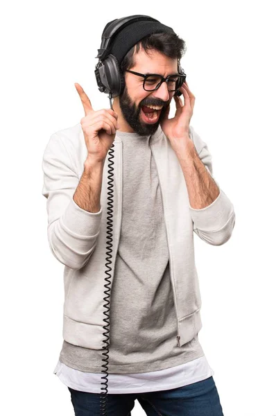 Feliz Hipster homem ouvindo música no fundo branco — Fotografia de Stock