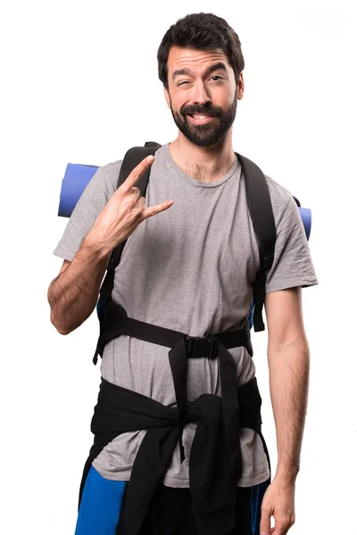 Handsome backpacker making rock gesture on white background — Stock Photo, Image