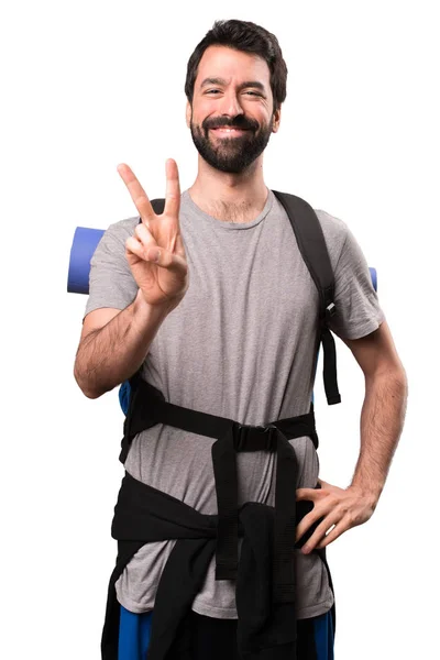 Handsome backpacker counting two on white background — Stock Photo, Image