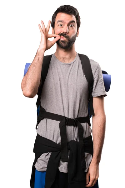Handsome backpacker making silence gesture on white background — Stock Photo, Image