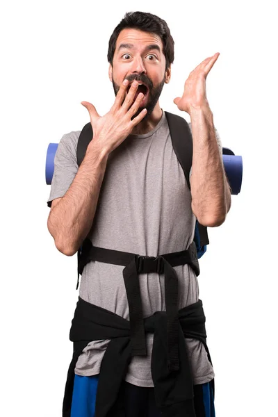 Przystojny backpacker podejmowania gest niespodzianka na białym tle — Zdjęcie stockowe