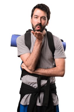 Yakışıklı backpacker beyaz arka plan üzerinde bir öpücük gönderme