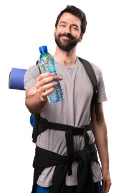 Bir şişe su üzerinde beyaz backgr ile mutlu yakışıklı backpacker