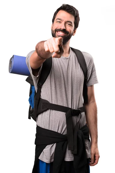 Handsome backpacker pointing to the front on white background — Stock Photo, Image