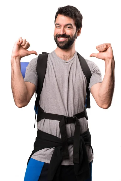 Handsome backpacker proud of himself on white background — Stock Photo, Image