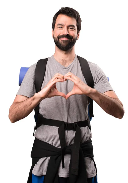 Bello backpacker fare un cuore con le mani su bianco schienale — Foto Stock