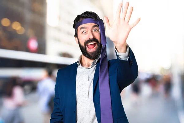 Verrückter und betrunkener Geschäftsmann salutiert vor unkonzentriertem Hintergrund — Stockfoto