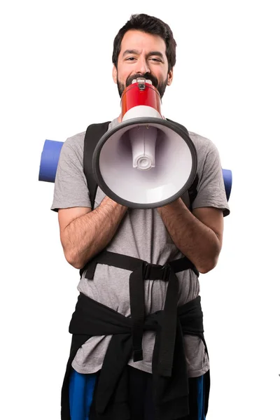 Hezký batohem drží megafon na bílém pozadí — Stock fotografie